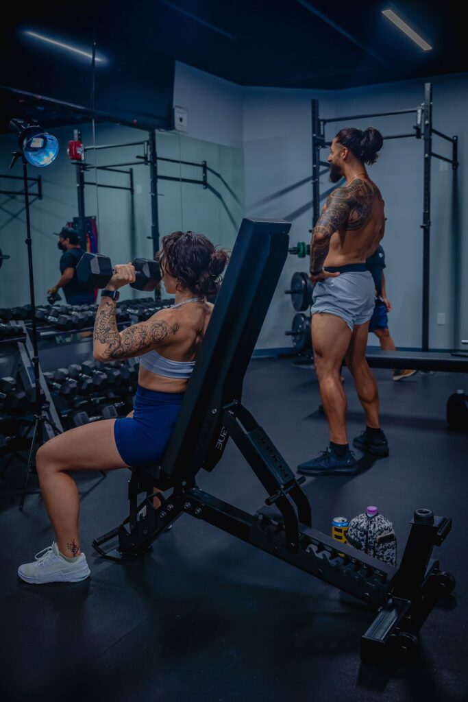 Socios entrenando con mancuernas en la sala de un gimnasio